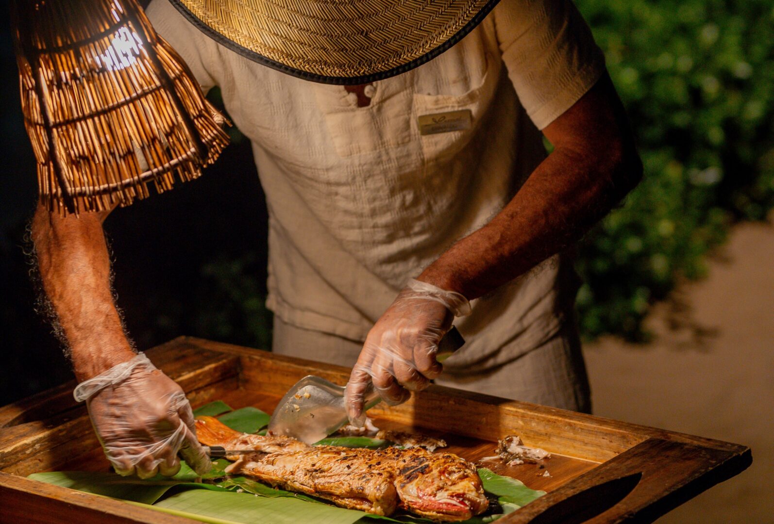 Pescador preparando o peixe na experiência do pescado rústico que exalta os sabores da gastronomia cearense.
