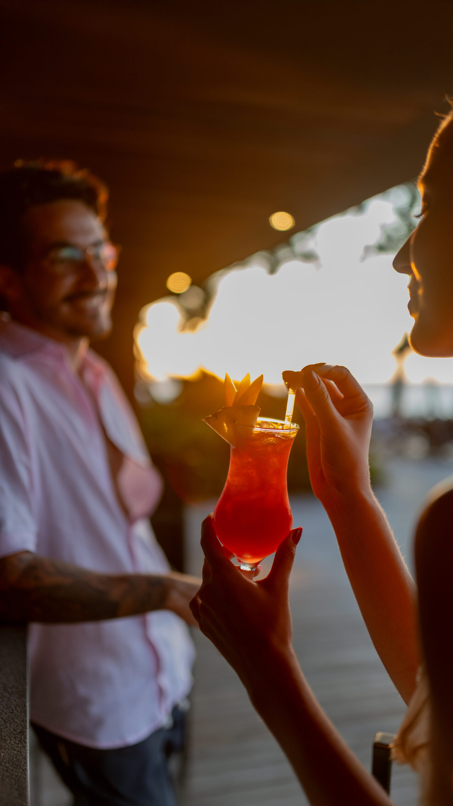 Casal saboreando drinks na beira da piscina