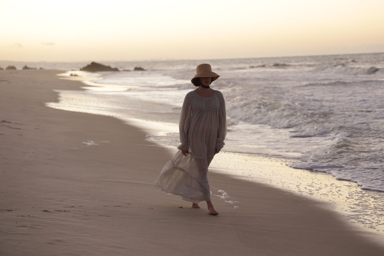 Mulher caminhando pela praia do barro preto no fim de ano