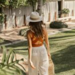 Mulher caminhando pela grama de um hotel de luxo em sua viagem solo